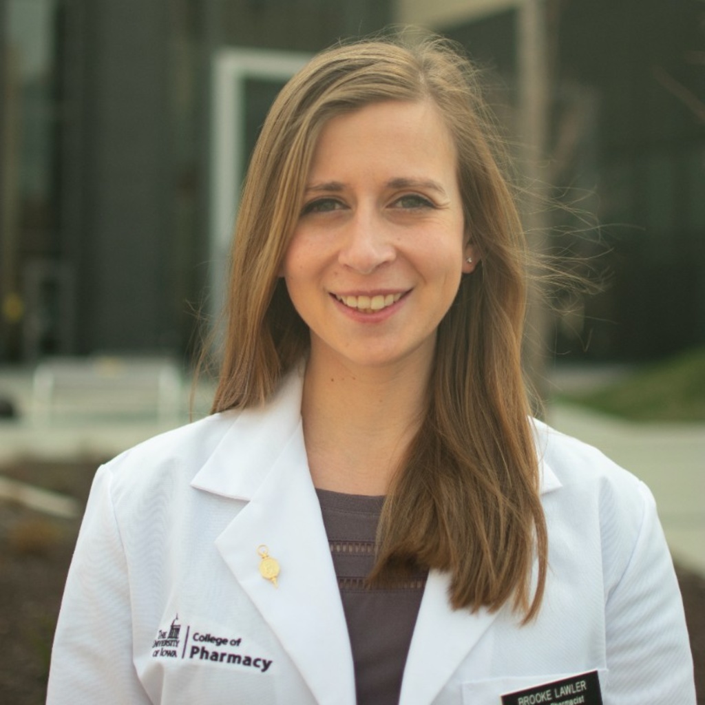 Brooke Lawler smiles into the camera and wears a College of Pharmacy lab coat